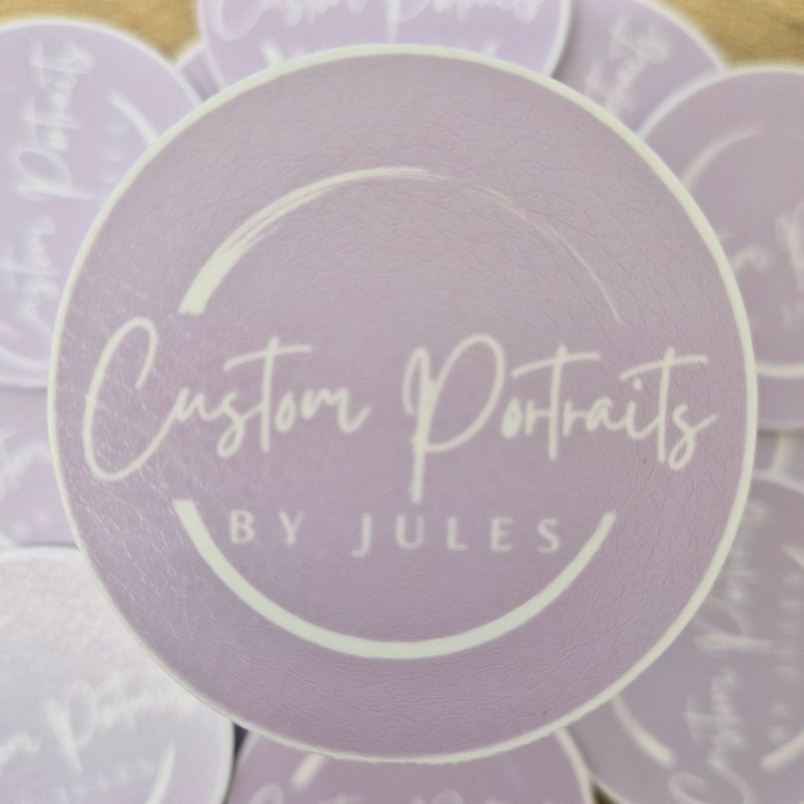 Stack of lavender coasters with 'Custom Portraits by Jules' branding on a wooden surface.